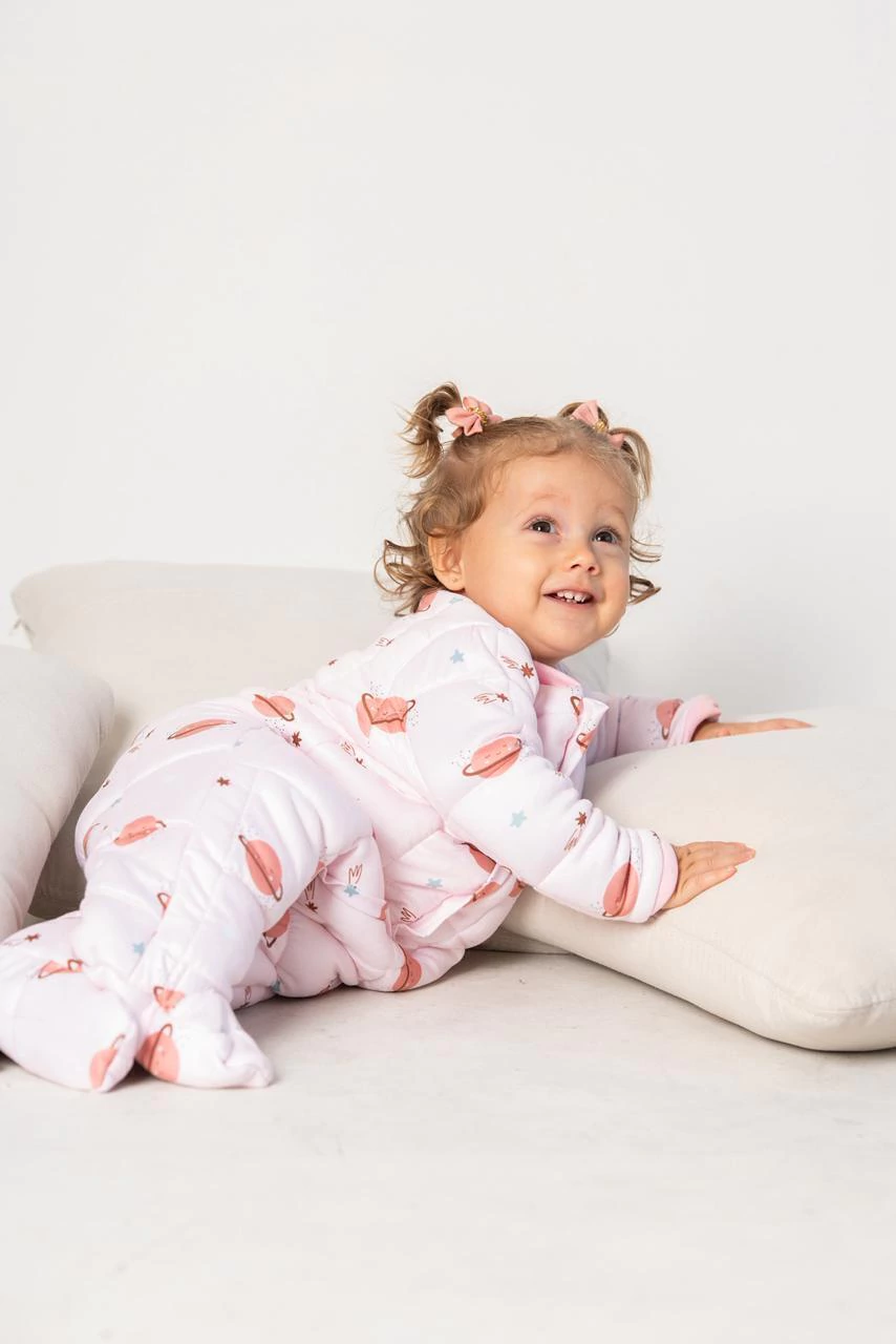 Bebê sorrindo e engatinhando com pijama ponderado rosa Meu Snugg
